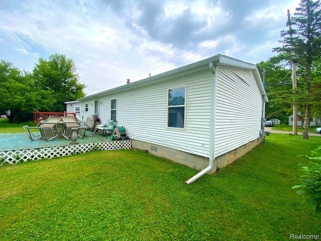 5424 Hughes Rd, Lansing, MI 48911 - rear view of house with crawl space, a wooden deck, and a lawn