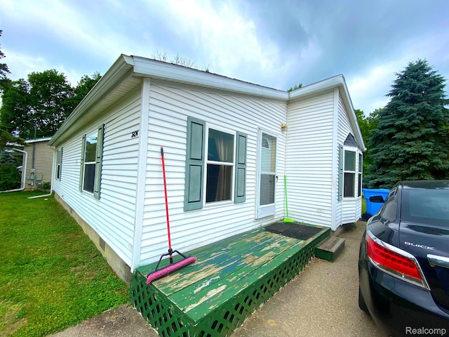 5424 Hughes Rd, Lansing, MI 48911 - view of side of property with a yard and a wooden deck