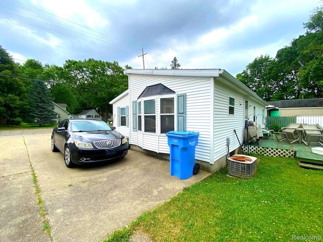 5424 Hughes Rd, Lansing, MI 48911 - view of side of home with a lawn and a deck