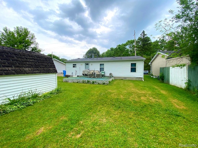 5424 Hughes Rd, Lansing, MI 48911 - back of house with a lawn, a deck, and a storage shed