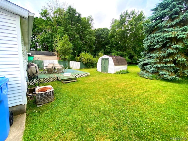5424 Hughes Rd, Lansing, MI 48911 - view of grassy yard featuring a shed and a deck