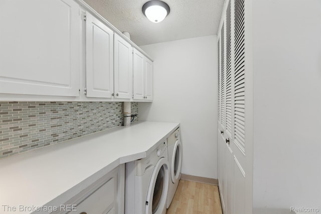 9451 Parkwood N, Davison, MI 48423 - washroom with separate washer and dryer, cabinet space, light wood-style floors, and a textured ceiling