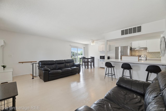 9451 Parkwood N, Davison, MI 48423 - living room with light wood-type flooring, ceiling fan, and a textured ceiling