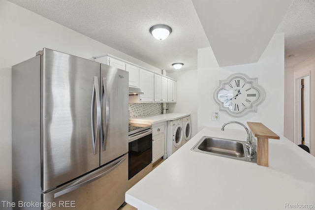 9451 Parkwood N, Davison, MI 48423 - kitchen featuring stainless steel appliances, under cabinet range hood, separate washer and dryer, light countertops, and white cabinets