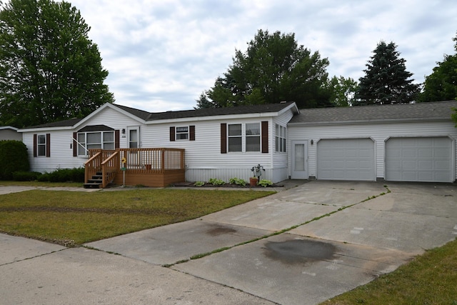 4105 Sawgrass Trl, Muskegon, MI 49442 - manufactured / mobile home featuring a garage, driveway, a front lawn, and a deck