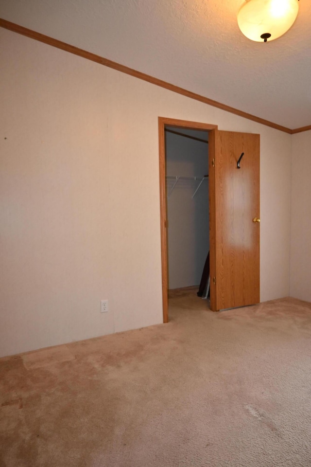 4105 Sawgrass Trl, Muskegon, MI 49442 - unfurnished bedroom with carpet, lofted ceiling, ornamental molding, a textured ceiling, and a closet