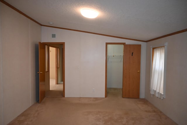4105 Sawgrass Trl, Muskegon, MI 49442 - unfurnished bedroom with vaulted ceiling, carpet, ornamental molding, a textured ceiling, and a spacious closet