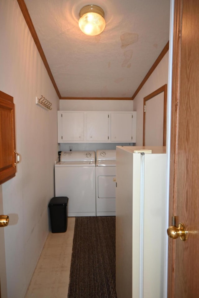 4105 Sawgrass Trl, Muskegon, MI 49442 - laundry room featuring washer and clothes dryer, cabinet space, ornamental molding, and tile patterned floors