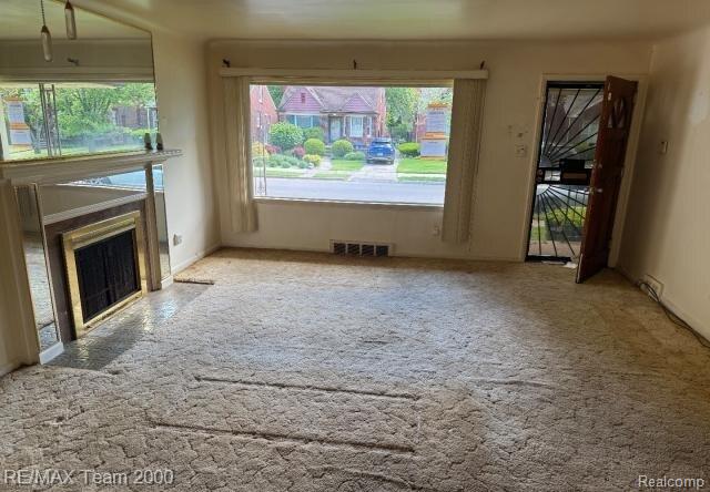 3929 Grayton St, Detroit, MI 48224 - unfurnished living room featuring a fireplace with flush hearth and carpet flooring