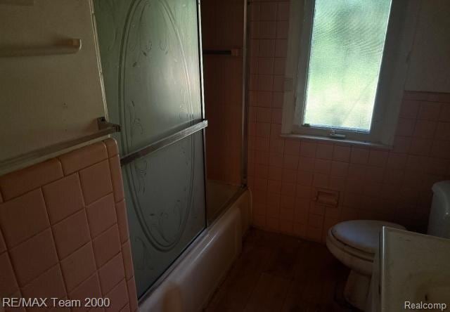 3929 Grayton St, Detroit, MI 48224 - full bathroom with tile walls, vanity, and bath / shower combo with glass door