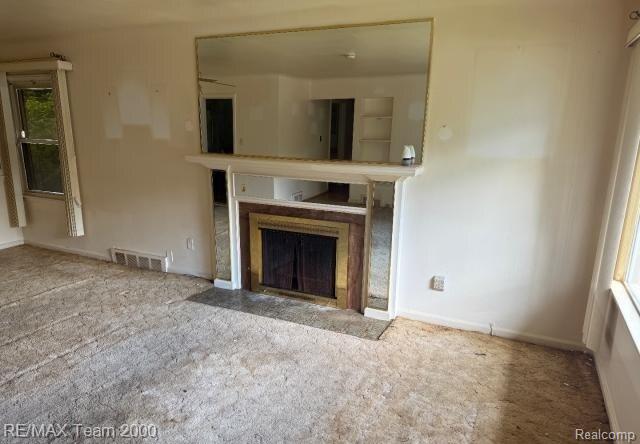 3929 Grayton St, Detroit, MI 48224 - unfurnished living room featuring a fireplace with flush hearth and carpet flooring