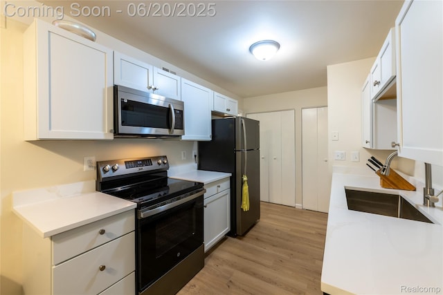 16591MIDDLEBELTRD Middlebelt Rd Unit 4, Livonia, MI 48154 - kitchen featuring stainless steel appliances, light wood finished floors, light countertops, and white cabinetry