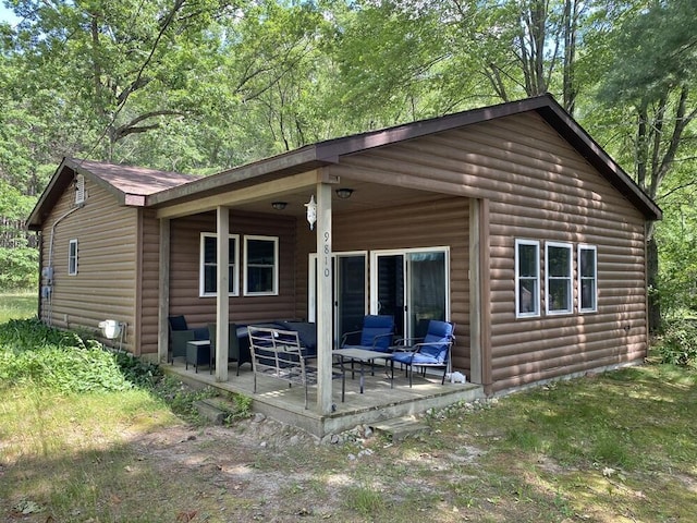 9810 E School Section Lake Dr, Mecosta, MI 49332 - back of house featuring faux log siding and a patio area