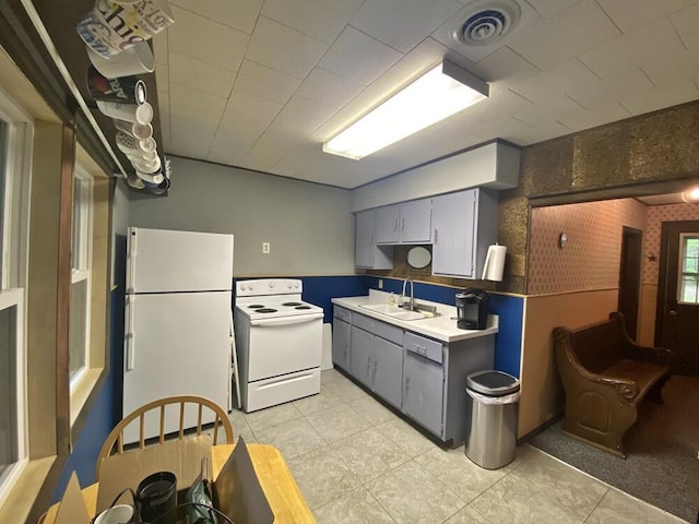 9810 E School Section Lake Dr, Mecosta, MI 49332 - kitchen with white appliances, gray cabinetry, and light tile patterned flooring