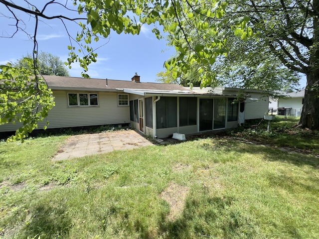 1358 Neece Dr, Norton Shores, MI 49441 - back of property featuring a sunroom, a patio, a chimney, and a lawn