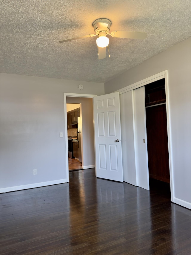 1358 Neece Dr, Norton Shores, MI 49441 - unfurnished bedroom featuring a textured ceiling, dark wood-type flooring, a closet, and a ceiling fan