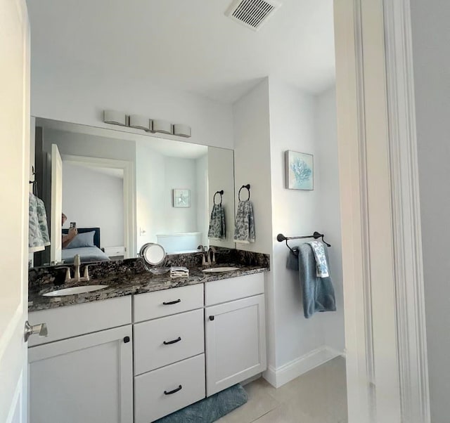 982 Lake Ridge Dr, Traverse City, MI 49684 - bathroom featuring double vanity, ensuite bathroom, and tile patterned flooring