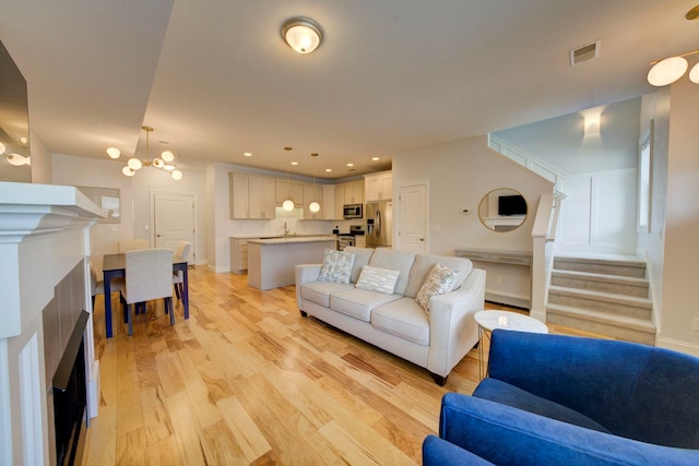 982 Lake Ridge Dr, Traverse City, MI 49684 - living area with light wood-style flooring, stairs, a fireplace, and recessed lighting