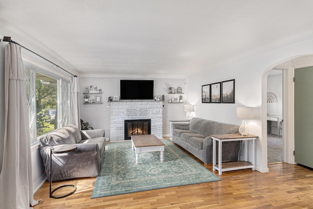 8565 Rives Junction Rd, Rives Junction, MI 49277 - living room with a stone fireplace, arched walkways, and wood finished floors