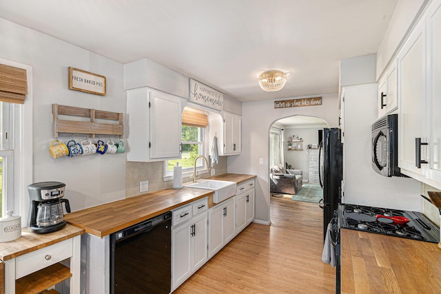 8565 Rives Junction Rd, Rives Junction, MI 49277 - kitchen with wood counters, black appliances, arched walkways, light wood finished floors, and white cabinets