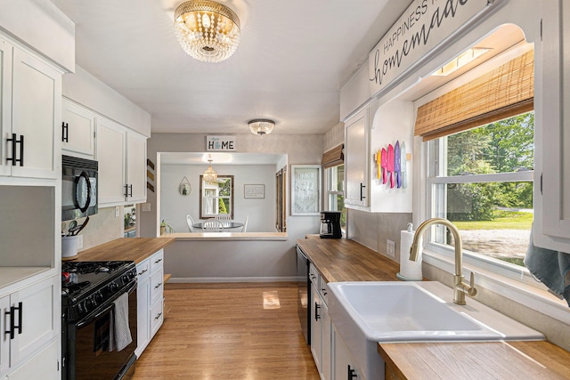 8565 Rives Junction Rd, Rives Junction, MI 49277 - kitchen featuring black appliances, butcher block counters, a chandelier, and white cabinets