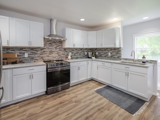 520 Della St, Portage, MI 49002 - kitchen featuring stainless steel electric stove, wall chimney exhaust hood, white cabinetry, light wood-style floors, and recessed lighting
