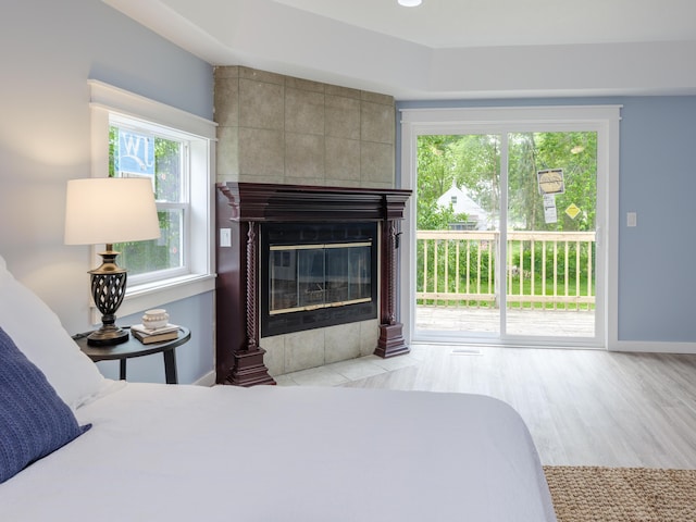 520 Della St, Portage, MI 49002 - bedroom featuring access to outside, a tiled fireplace, and wood finished floors