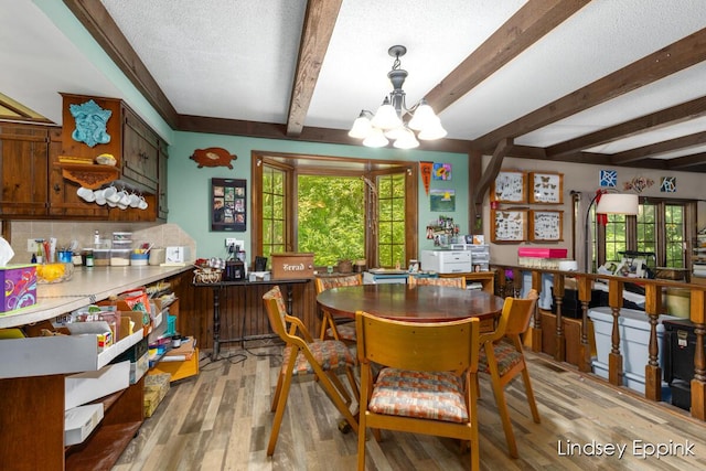 10201 Fillmore St, Zeeland, MI 49464 - dining area featuring a chandelier, beamed ceiling, light wood-style flooring, and a textured ceiling
