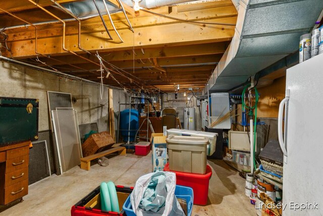 10201 Fillmore St, Zeeland, MI 49464 - unfinished basement featuring freestanding refrigerator, water heater, and a water pressure tank