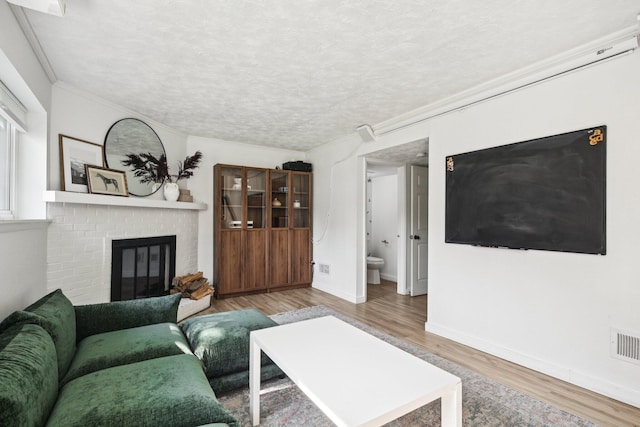 9241 Abbey Ln, Ypsilanti, MI 48198 - living area with wood finished floors, crown molding, a brick fireplace, and a textured ceiling
