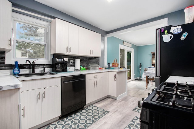 6779 1st Dr, Coloma, MI 49038 - kitchen featuring black appliances, light countertops, tasteful backsplash, and light wood-style floors