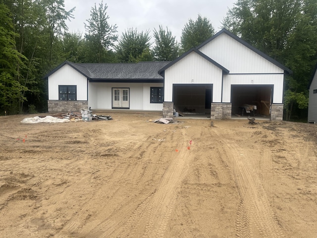 1513 Browning Dr, Grand Rapids, MI 49534 - view of front of home featuring stone siding, dirt driveway, an attached garage, and a shingled roof