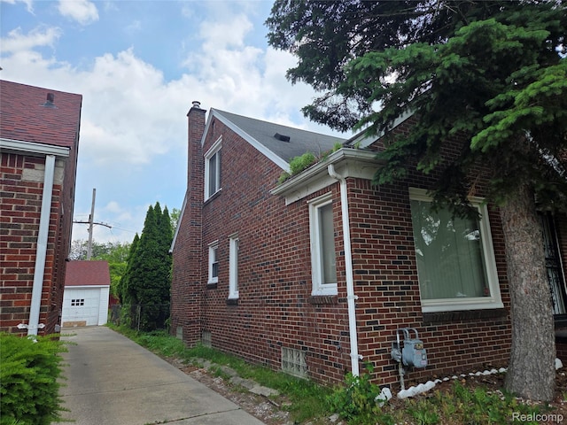 19466 Packard St, Detroit, MI 48234 - view of home's exterior with a chimney, brick siding, and a garage