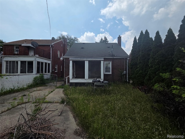 19466 Packard St, Detroit, MI 48234 - back of property featuring a sunroom, a chimney, and brick siding