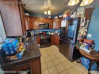 1693 Marion Ave, Lincoln Park, MI 48146 - kitchen featuring stainless steel appliances, light tile patterned floors, and brown cabinets