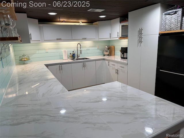 4235 Bacon Ave, Berkley, MI 48072 - kitchen with marble finish floors, light stone counters, white cabinets, freestanding refrigerator, and recessed lighting