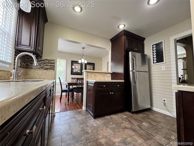 4235 Bacon Ave, Berkley, MI 48072 - kitchen with freestanding refrigerator, backsplash, dark brown cabinetry, a chandelier, and recessed lighting