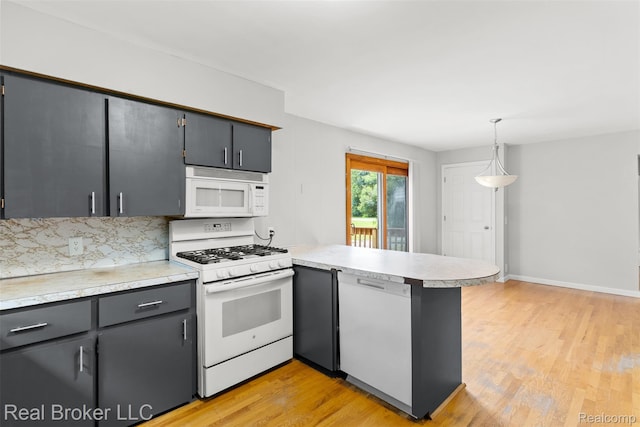 1059 Morris Hills Pkwy, Mount Morris, MI 48458 - kitchen featuring white appliances, a peninsula, light wood-style floors, light countertops, and hanging light fixtures