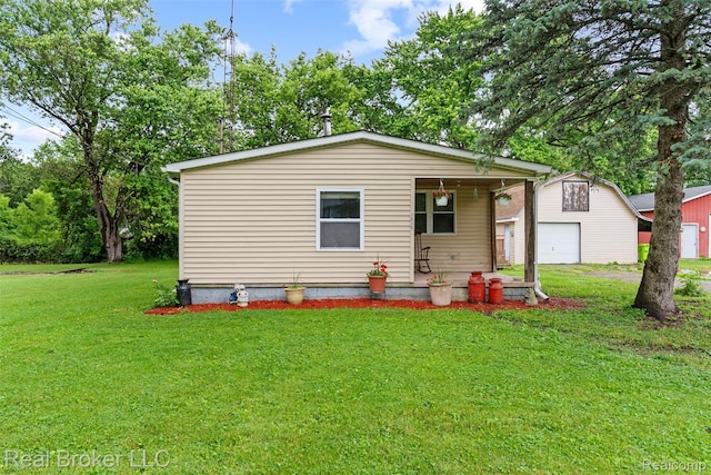 1059 Morris Hills Pkwy, Mount Morris, MI 48458 - bungalow-style home with covered porch, a front yard, a garage, and an outbuilding