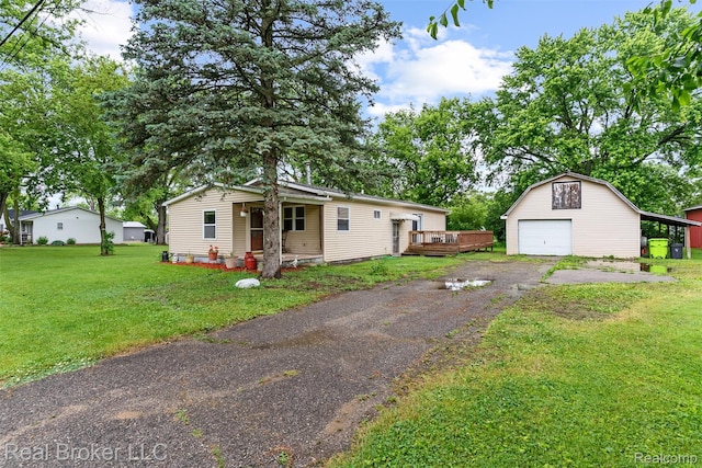 1059 Morris Hills Pkwy, Mount Morris, MI 48458 - view of front of house with a detached garage, an outdoor structure, a front yard, driveway, and a wooden deck