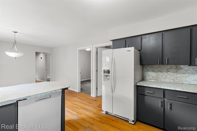 1059 Morris Hills Pkwy, Mount Morris, MI 48458 - kitchen featuring white appliances, light countertops, hanging light fixtures, and light wood-type flooring