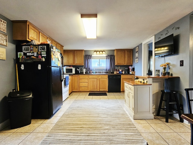 209 Sarah St, Adrian, MI 49221 - kitchen with black appliances, light tile patterned flooring, brown cabinets, and a peninsula