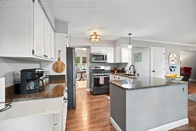 4386 Kelly Circle Dr, Commerce Twp, MI 48390 - kitchen featuring stainless steel appliances, a peninsula, white cabinetry, wood finished floors, and crown molding