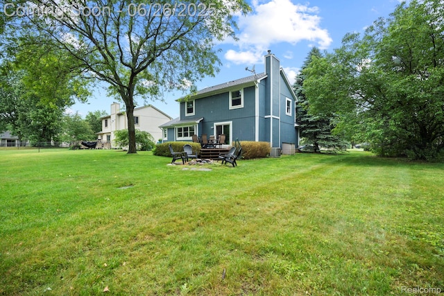 4386 Kelly Circle Dr, Commerce Twp, MI 48390 - back of house with a yard and a chimney