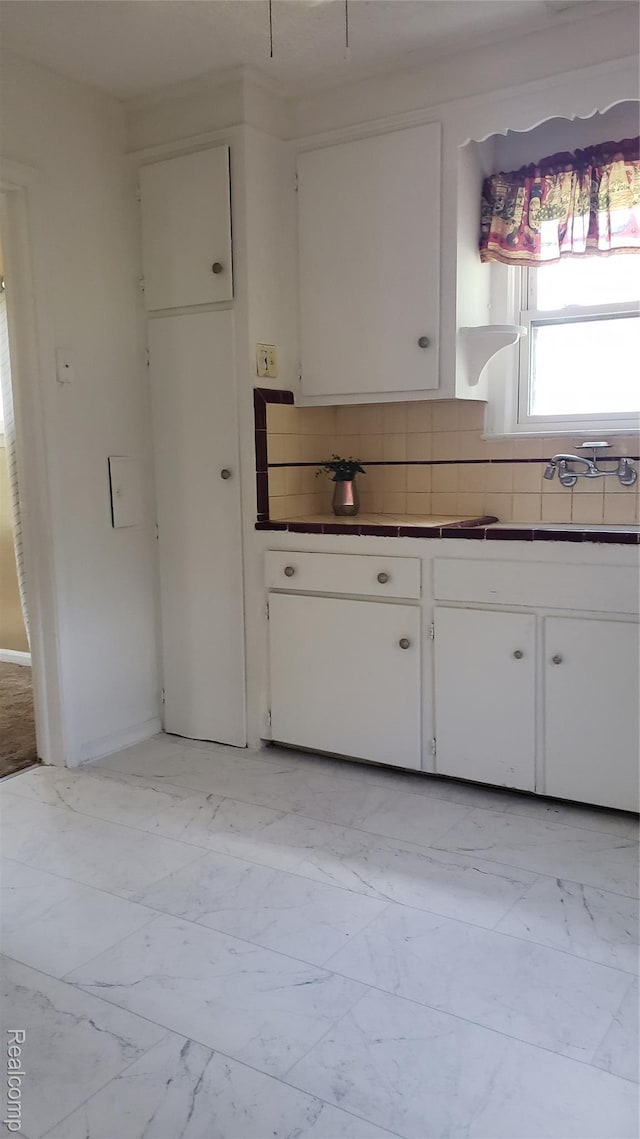 18968 Asbury Park, Detroit, MI 48235 - kitchen with light marble finish floors, decorative backsplash, and white cabinets