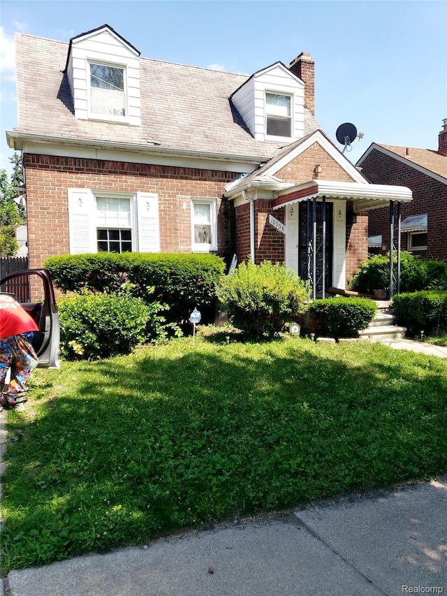 18968 Asbury Park, Detroit, MI 48235 - view of front of home with brick siding, a front yard, and a chimney