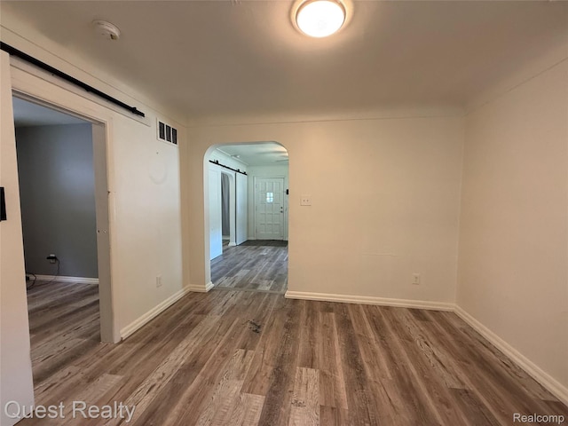 21738 Evergreen St, Saint Clair Shores, MI 48082 - spare room featuring arched walkways, wood finished floors, and a smoke detector