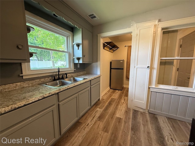 21738 Evergreen St, Saint Clair Shores, MI 48082 - kitchen featuring freestanding refrigerator, gray cabinetry, and wood finished floors