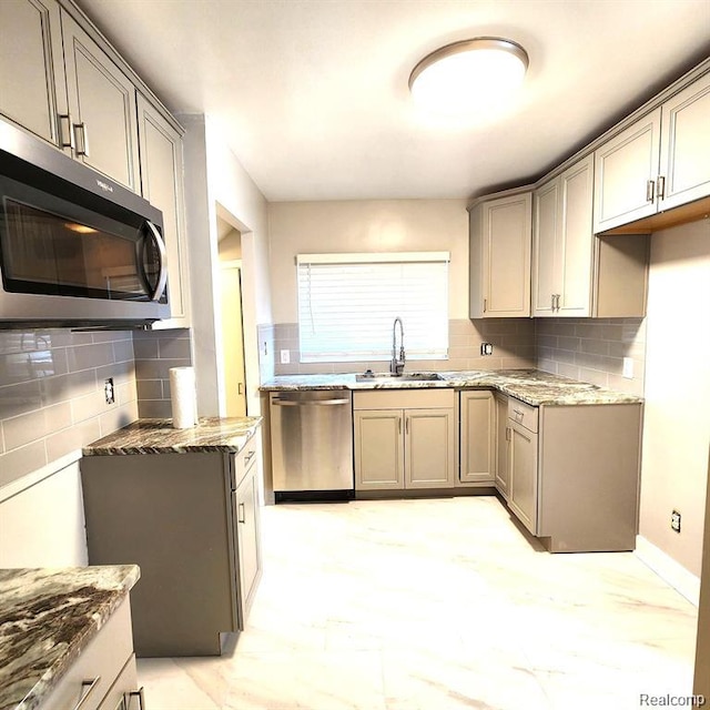 16598 Biltmore St, Detroit, MI 48235 - kitchen featuring appliances with stainless steel finishes, light stone countertops, tasteful backsplash, and gray cabinets