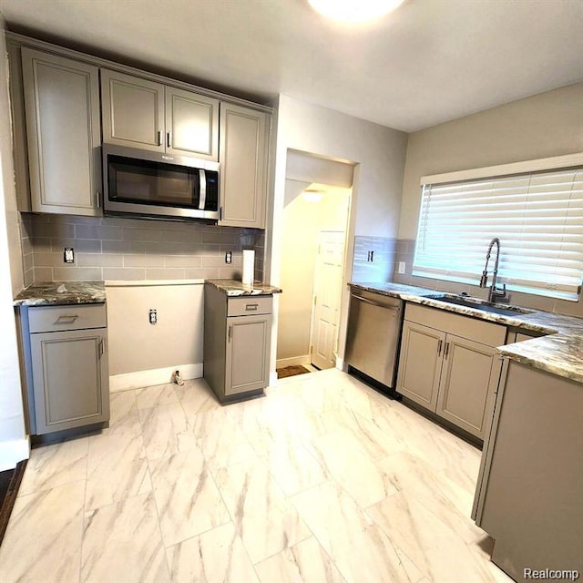 16598 Biltmore St, Detroit, MI 48235 - kitchen featuring appliances with stainless steel finishes, gray cabinetry, light marble finish flooring, decorative backsplash, and stone counters